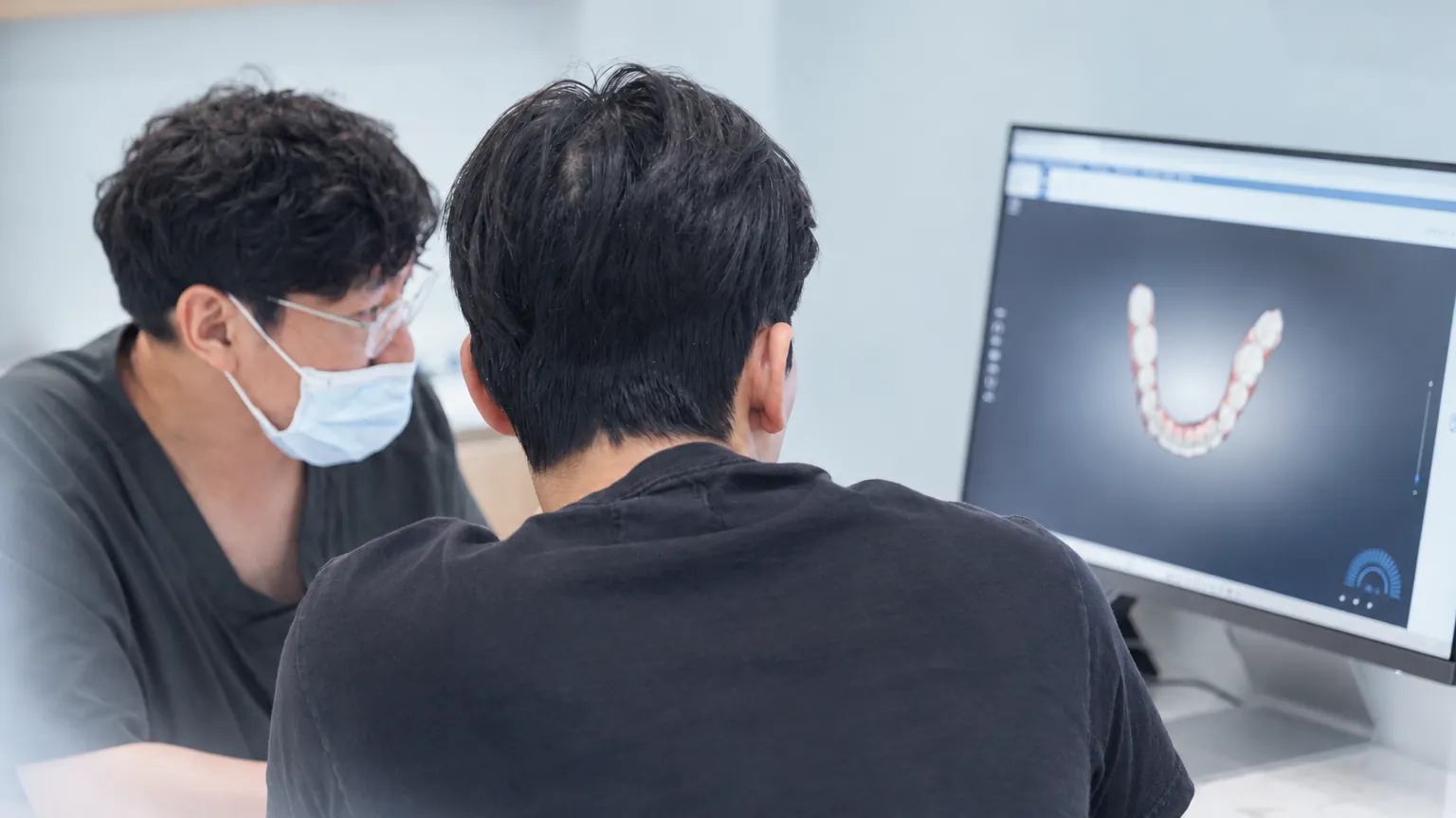 모니터의 3D 치아 스캔을 환자와 함께 보는 원장